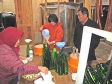 濁り酒を手詰めで瓶詰めしています